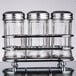 A Tablecraft fluted glass condiment shaker set on a metal rack.