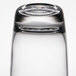 A close up of an Arcoroc customizable cooler glass on a table in a bar.