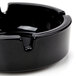 A black Arcoroc round glass ashtray with a handle.