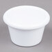 A close-up of a white Carlisle smooth melamine ramekin.