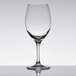 A close-up of a clear Stolzle Nadine Bordeaux wine glass on a reflective surface.