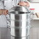 A chef using a Town 12" aluminum steamer pot.