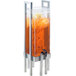 A Cal-Mil metal beverage dispenser with an infusion chamber filled with orange juice on a stand.