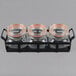 A black metal tray holding three glass jars with black lids.