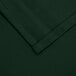 A close up of a hunter green hemmed fabric corner.