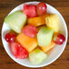 An Arcoroc Rondo china bowl filled with fruit on a table.