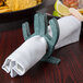 A cactus-shaped HS Inc. napkin holder on a table.