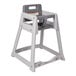 A gray Koala Kare high chair with a tray on a table.