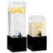 A couple of Cal-Mil black square bases for glass beverage dispensers filled with water, lemons, and ice.