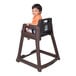 A child sitting in a brown Koala Kare high chair.