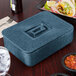 A blue HS Inc. multi-purpose container with a lid on a table.
