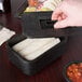 A person holding a HS Inc. charcoal black multi-purpose container with tortillas inside.