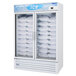 A Turbo Air white glass door freezer filled with bags of ice.