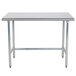A stainless steel Advance Tabco work table with metal legs.