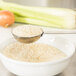 A Town rice scoop measuring spoon over a white bowl of rice.