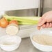 A person using a Town rice scoop to pour rice into a bowl.