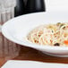 A CAC Super Bright White porcelain bowl filled with noodles and vegetables.