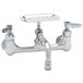 A chrome T&S wall mount pantry faucet with two handles and a swing nozzle.
