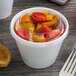 A clear Dart container lid on a container of food on a table.