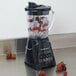 A Hamilton Beach Power Elite blender with ice and berries in it.