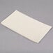 A Hoffmaster ivory paper dinner napkin on a gray surface.