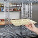 A hand holding a small tray in a Metro tray slide.
