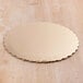 A gold laminated corrugated cake circle on a wood surface.