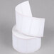 A white roll of Globe E10 standard labels on top of other white rolls.