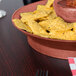 A bowl of salsa and chips in a HS Inc. paprika deli server on a table.