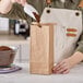 A person pouring coffee into a Choice brown paper bag.