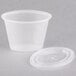 A stack of Pactiv oval plastic souffle containers with lids.