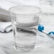 A clear Solo Ultra Clear plastic cup filled with water next to a toothbrush.