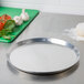 An American Metalcraft heavy weight aluminum pizza pan on a counter.