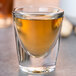 A Libbey shot glass filled with brown liquid.