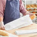 A person holding a Bagcraft white paper bread bag full of bread.