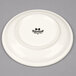 A white Tuxton cappuccino saucer with black text that reads "Tuxton"