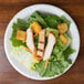 A plate of chicken salad with croutons on a Dart white foam plate.