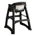 A black plastic restaurant high chair with wheels designed for child safety.