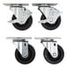 Four black Beverage-Air plate casters with black rubber wheels.