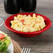 A black Tuxton China bowl filled with macaroni and cheese.
