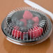 A Dart clear plastic dome lid on a container of berries.