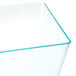 A clear plastic cube bowl with a green edge.