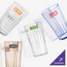 A group of empty Cambro Newport plastic tumblers with a clear glass with a green logo.