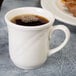 A Homer Laughlin ivory china cup with coffee and a white handle.