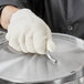 a person wearing a glove holding a metal object