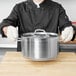 A person wearing Cordova seamless loop in terry gloves holding a pot.