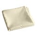 A folded ivory square cloth on a white background.