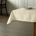A table with an ivory Intedge tablecloth and plates on it.
