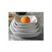 A stack of square white CAC Princesquare porcelain bowls with an orange in one.
