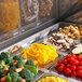 A tray of food in a Turbo Air refrigerated sandwich prep table with a mega top display of broccoli and carrots.